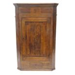 A 19thC oak and mahogany cross banded corner cabinet, with a single panelled door, inlaid with a mar