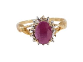 A dress ring, set with three dark red semi precious stones, comprising an oval central stone, in fou