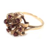 A 9ct gold cluster ring, the twist cluster set with arrangement of seven garnets, each in claw setti