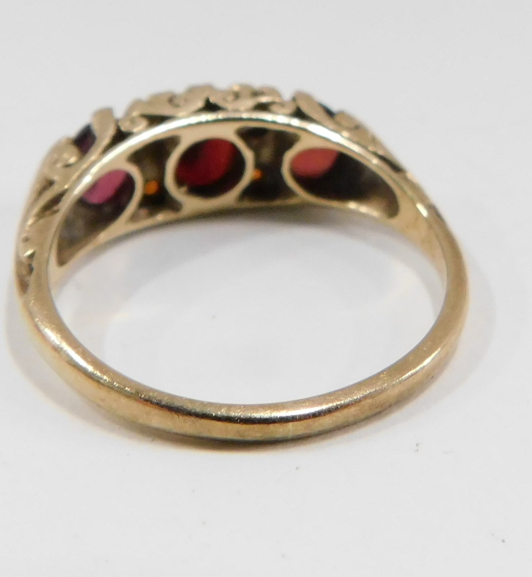 A 9ct gold garnet dress ring, set with three oval garnets and four round brilliant cut garnets, in g - Image 2 of 2