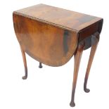A walnut oval drop leaf table, the figured top with a cross banded edge, on slender cabriole legs wi