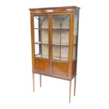 An Edwardian mahogany boxwood strung display cabinet, with two glazed doors, on square tapering legs