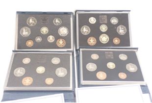 Four United Kingdom coin packs, comprising 1986, 1982, 1985, and 1987, boxed. (4)