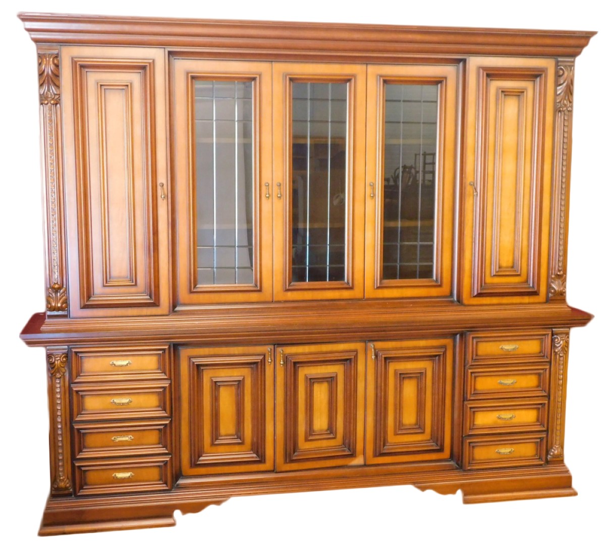 A large Continental walnut cabinet, the top with a moulded cornice above three glazed doors flanked