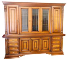 A large Continental walnut cabinet, the top with a moulded cornice above three glazed doors flanked