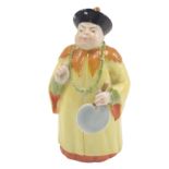 A Royal Worcester porcelain candle snuffer, formed as a figure in flowing yellow robe, 10cm high.