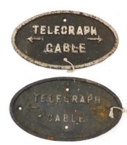 Two oval cast iron railway signs, Telegraph and Cable, 23cm wide.