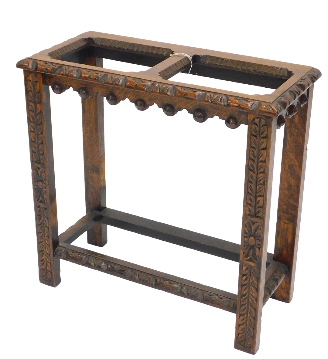 An early 20thC carved oak umbrella stand, with two divisions, lacking liner, 59.5cm wide.