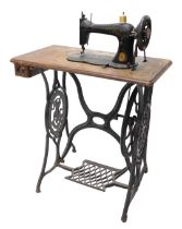 A Singer treddle sewing machine, on cast iron supports, 73cm wide.