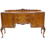 A figured and burr walnut sideboard, with a raised back, a serpentine shaped front with carved friez