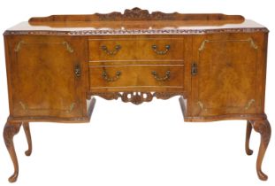 A figured and burr walnut sideboard, with a raised back, a serpentine shaped front with carved friez