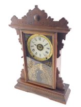 A late 19th/early 20thC American mantel clock, with a shaped walnut case, gilt decorated door, and a
