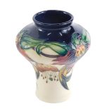A Moorcroft Anna Lily pattern vase, on a blue ground, with a cream border, dated 98 in red, 13cm hig