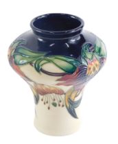 A Moorcroft Anna Lily pattern vase, on a blue ground, with a cream border, dated 98 in red, 13cm hig