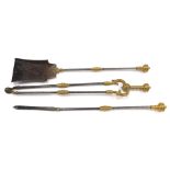 A set of three brass and steel fire irons, each with a part turned handle.