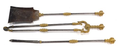 A set of three brass and steel fire irons, each with a part turned handle.