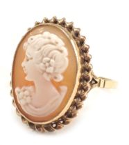 A 9ct gold shell cameo dress ring, the oval cameo depicting a figure looking dexter, in an oval rub