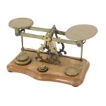 A set of late 19th/early 20thC walnut and brass letter scale, with some weights, 35cm wide.