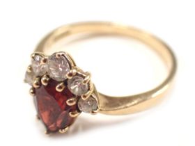 A 9ct gold dress ring, set with garnet and cz stones, the garnet of teardrop cut design, with three