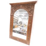 A carved oak overmantel mirror, the frame decorated with scrolls, fruit, roundels, etc., surrounding