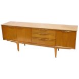 A 1960s/70s teak low sideboard, with arrangement of three drawers and three doors, on square taperin