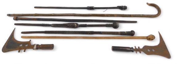 Two African axes or swords, each with a short handle, various tribal walking sticks, etc.