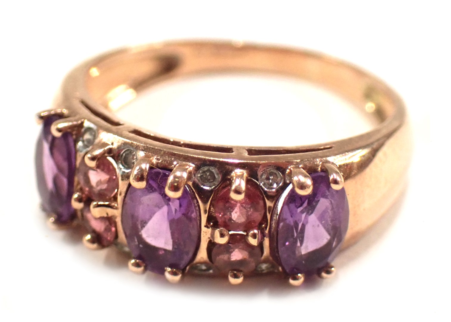 A 9ct rose gold dress ring, set with amethyst, pink topaz and cz, on half panelled design, ring