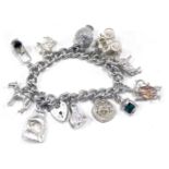 A silver and white metal charm bracelet, with curb link charms, padlock and safety chain, arrangemen