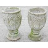 A pair of reconstituted urns, each cast with leaves on an octagonal base, 65cm high.