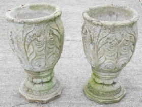 A pair of reconstituted urns, each cast with leaves on an octagonal base, 65cm high.