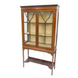 An Edwardian mahogany and boxwood strung display cabinet, with two glazed doors, on square tapering