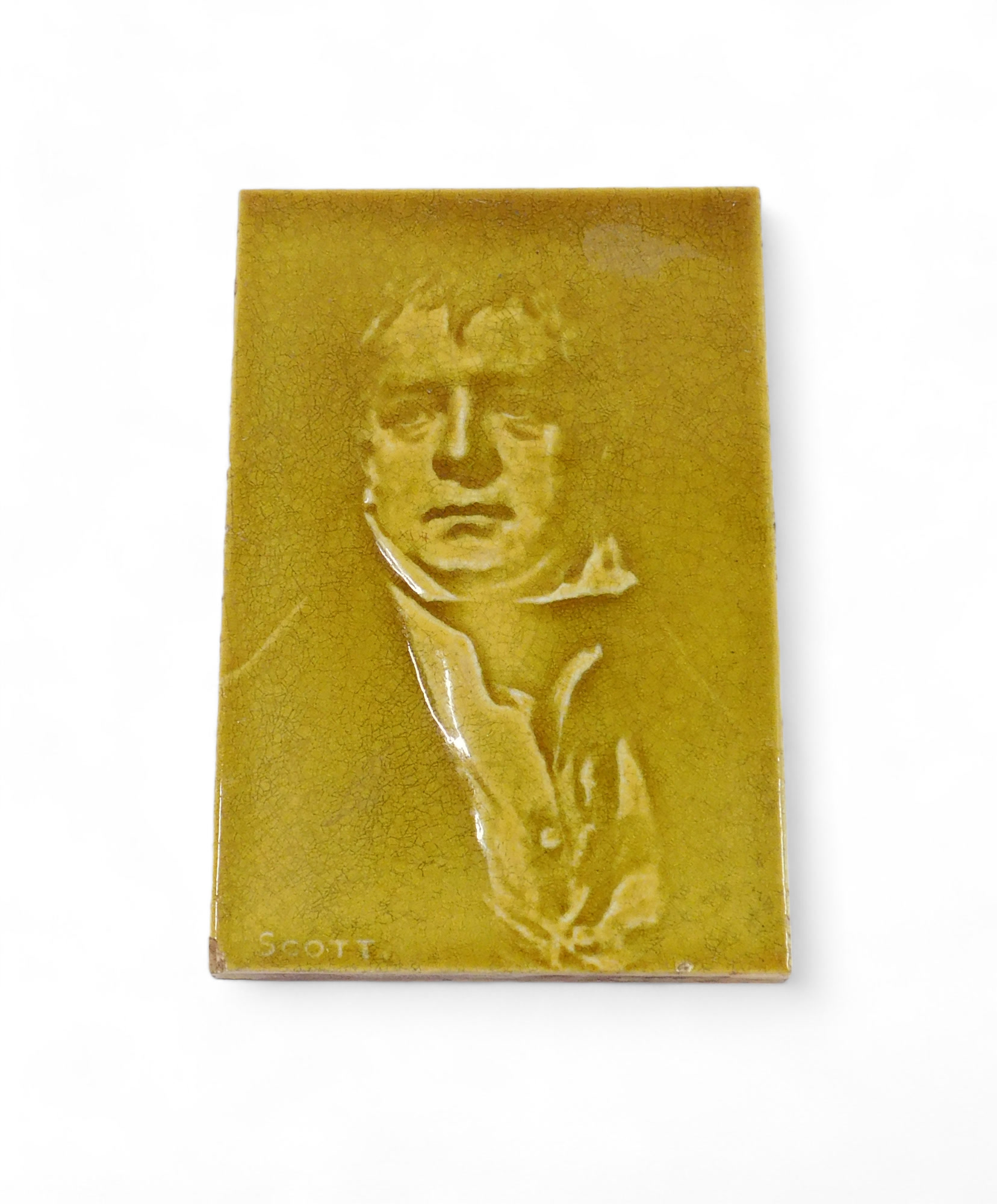 A 19thC ceramic tile, decorated with the face of Walter Scott, indistinctly stamped to underside PCD