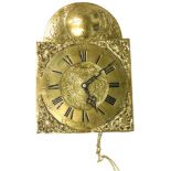A brass wall clock, signed Paul Wiedeman, with an arched top and Roman numerals, with pendulum