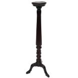 A mahogany plant stand or torchere, with a circular dish top, on a reeded column, with tripod base,
