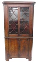 A George III oak standing corner cabinet, with a moulded cornice with two astragal glazed doors, the
