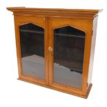 A Victorian pine bookcase, with a moulded cornice above two arched glazed doors, 116cm high, 124cm w
