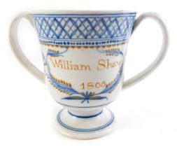 An early 19thC pearlware loving cup, named William Shaw and dated 1805, 13cm high. (AF)