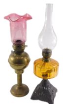 A Victorian oil lamp, with an amber tinted reservoir and a cast iron base, 57cm high, and a brass oi