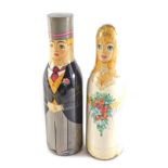 A pair of Russian painted bottle holders, each in the form of a bride and groom, 39cm and 36cm high.