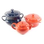 A Le Crueset blue stoneware casserole dish and cover, another similar in red, and a teapot. Buyer N