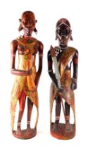A pair of African tribal figures of male and female, with coloured decoration, 66cm and 62cm high re