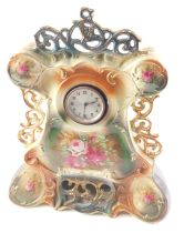 An early 20thC pottery clock case, printed with flowers, etc., mounted with a foreign movement, 46cm