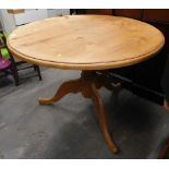 A pine circular kitchen table.