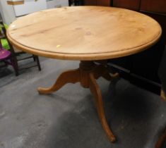 A pine circular kitchen table.