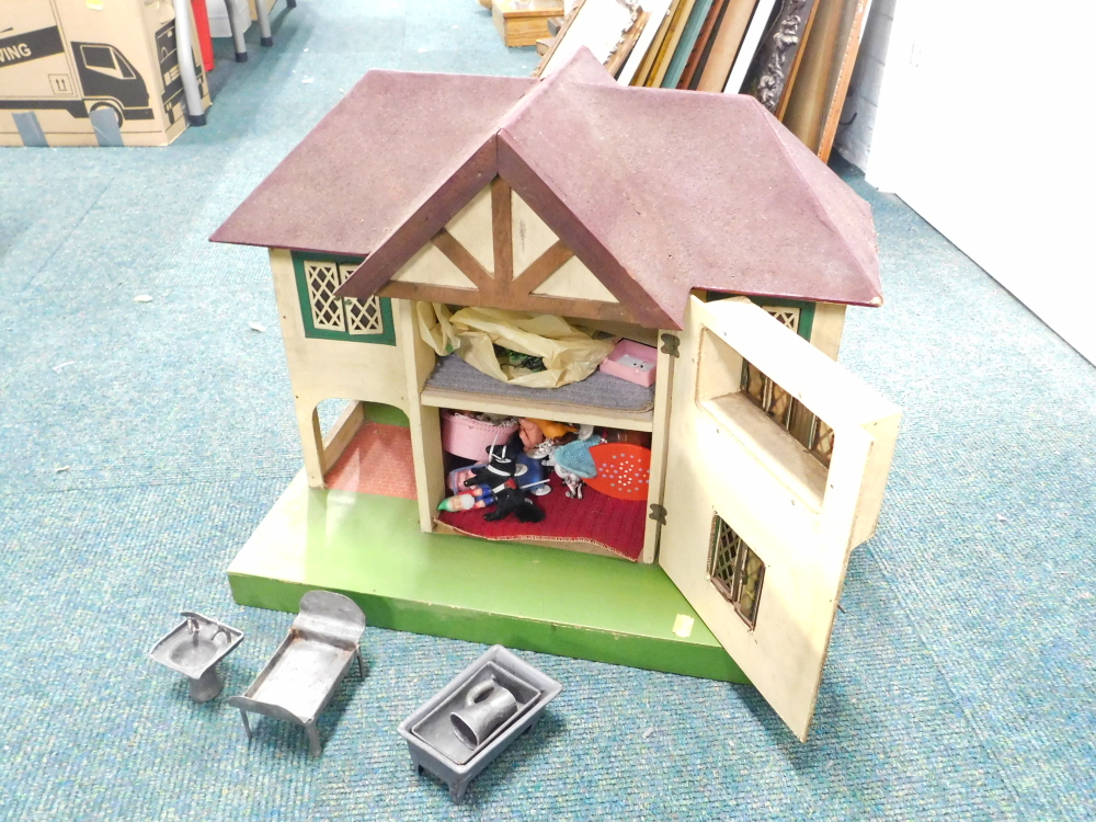 A mid century doll's house, containing some furniture.