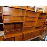 A retro style teak wall unit, in three sections to include cupboard top, cocktail cabinet and cupboa
