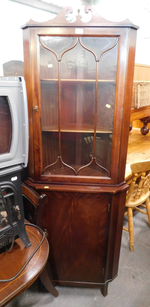 A reproduction mahogany corner cabinet, the top with arched pediment, above astragal glazed door, on