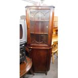 A reproduction mahogany corner cabinet, the top with arched pediment, above astragal glazed door, on