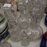 Four decanters, differing shapes and designs, together with a cut glass oil jar with stopper.