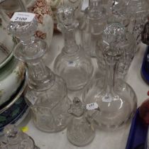 Four decanters, differing shapes and designs, together with a cut glass oil jar with stopper.